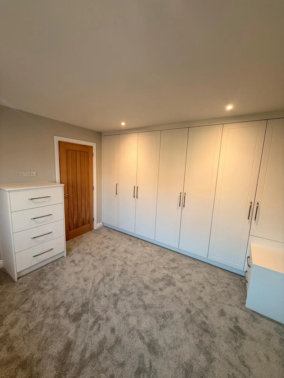 White built-in wardrobes and dressing unit with silver handles.