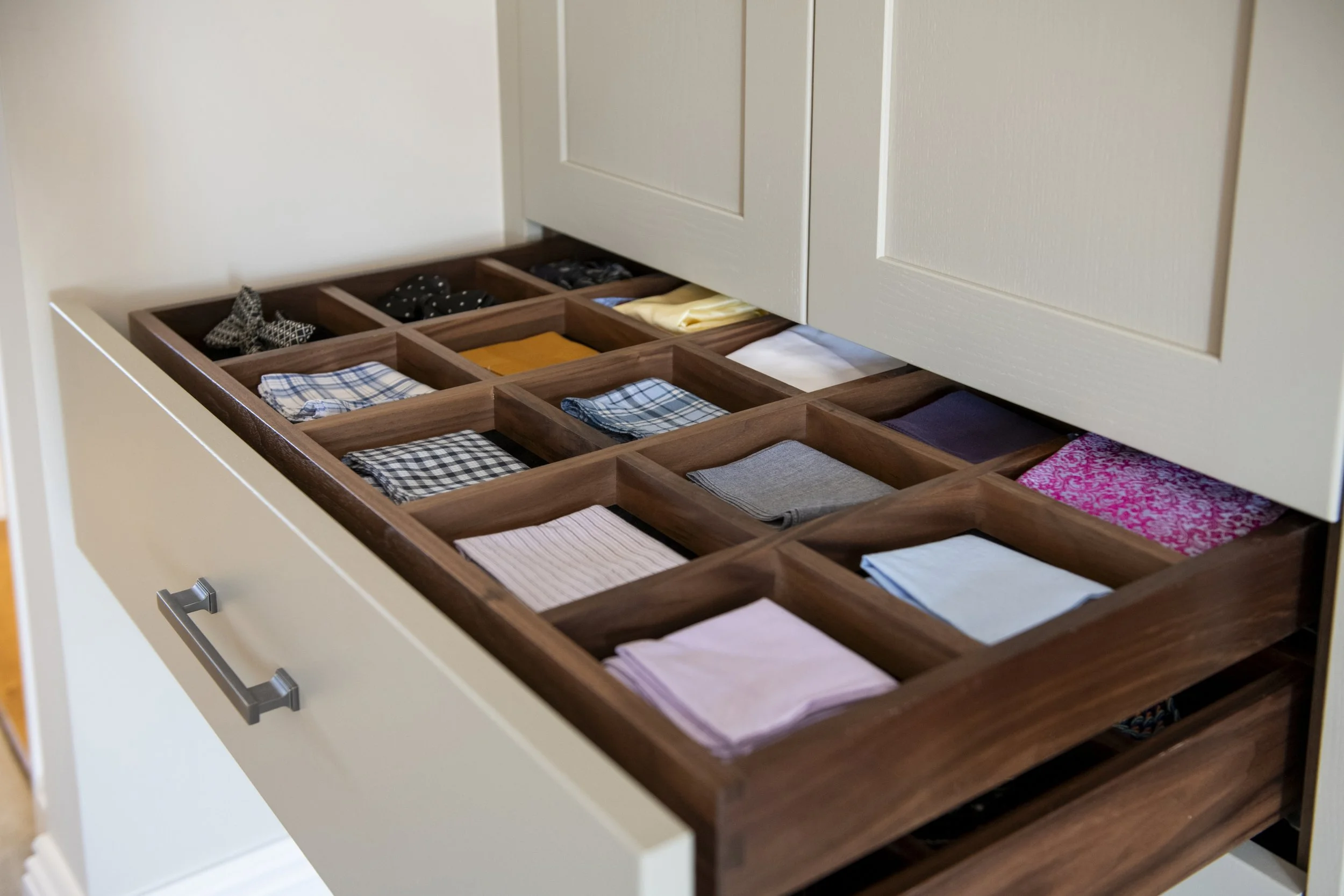 Open drawer with organized clothing, including pocket squares.