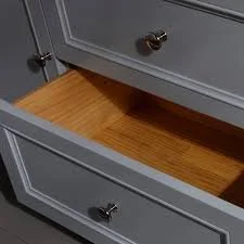 Open drawer in a grey wooden dresser, revealing a wooden interior from Croft & Assinder