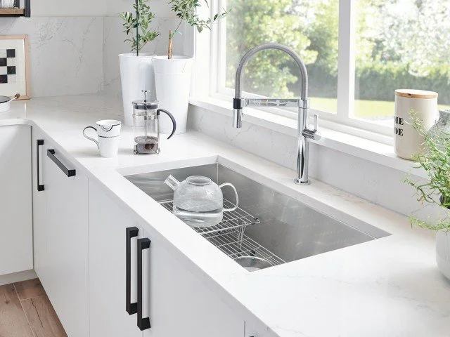 Clean white kitchen countertop with Blanco stainless steel sink and kitchen tap.
