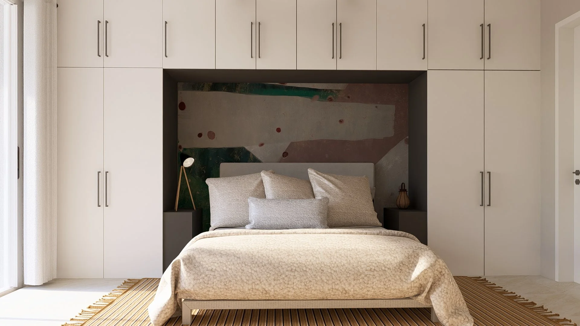 A neatly made bed with multiple beige pillows and a beige bedspread, set against a dark accent wall with a colorful abstract mural, flanked by two small black nightstands with decorative lamps and a vase, in a modern bedroom with white closets and a sliding glass door.