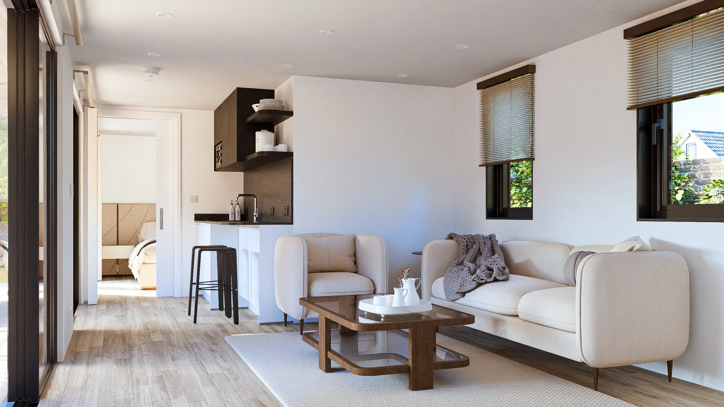 Bauhu hurricane resistant modular homeLiving room with beige sofa, armchair, wooden coffee table, and black window blinds, connected to a small kitchen with black cabinets and a barstool, leading into a bedroom visible through a doorway.