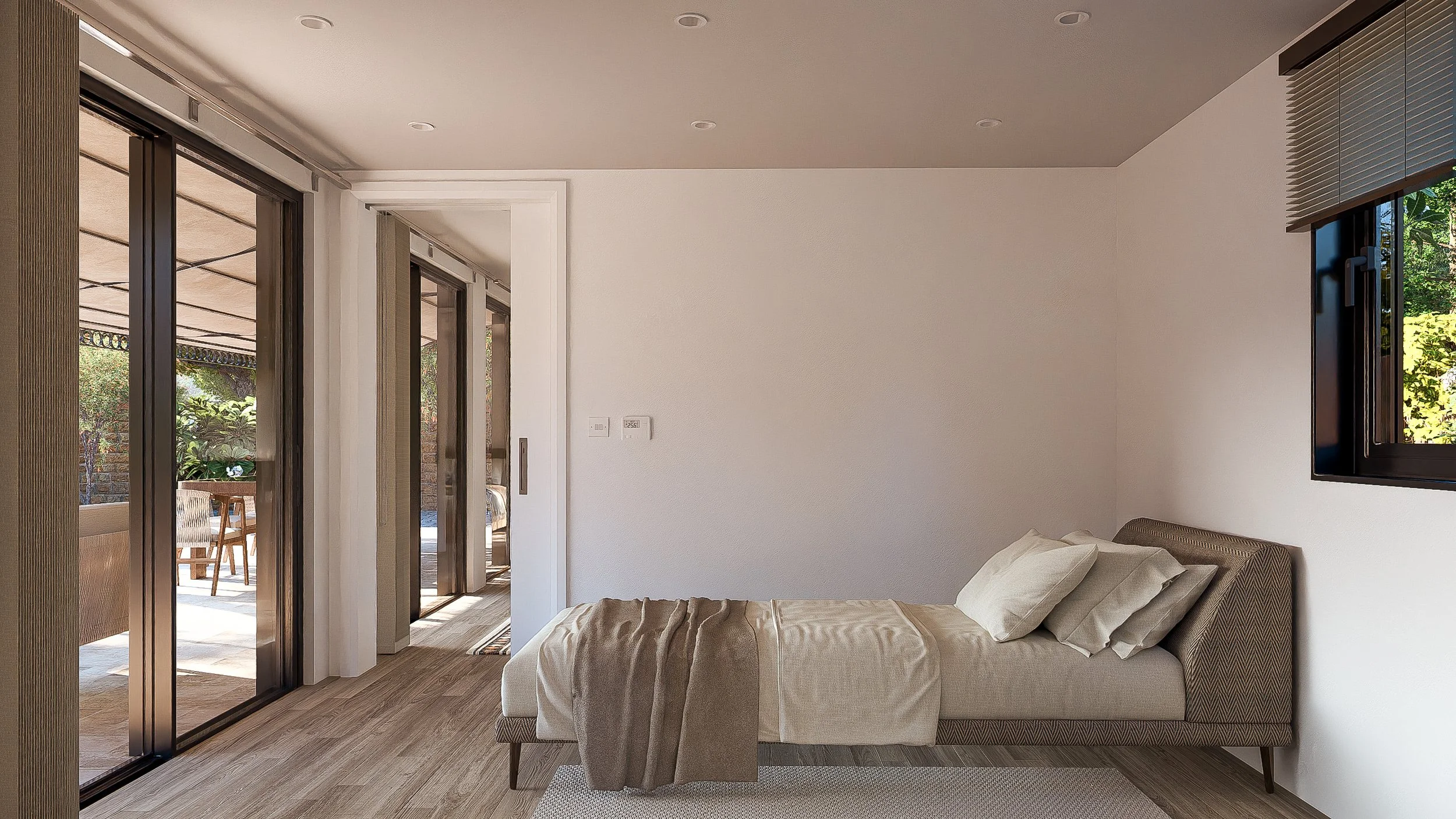 Minimalist Bauhu hurricane resistant modular hospitality pod bedroom with a single bed, beige linens, and pillows. Large sliding glass doors open to an outdoor patio with dining furniture, and a window with blinds shows greenery outside.