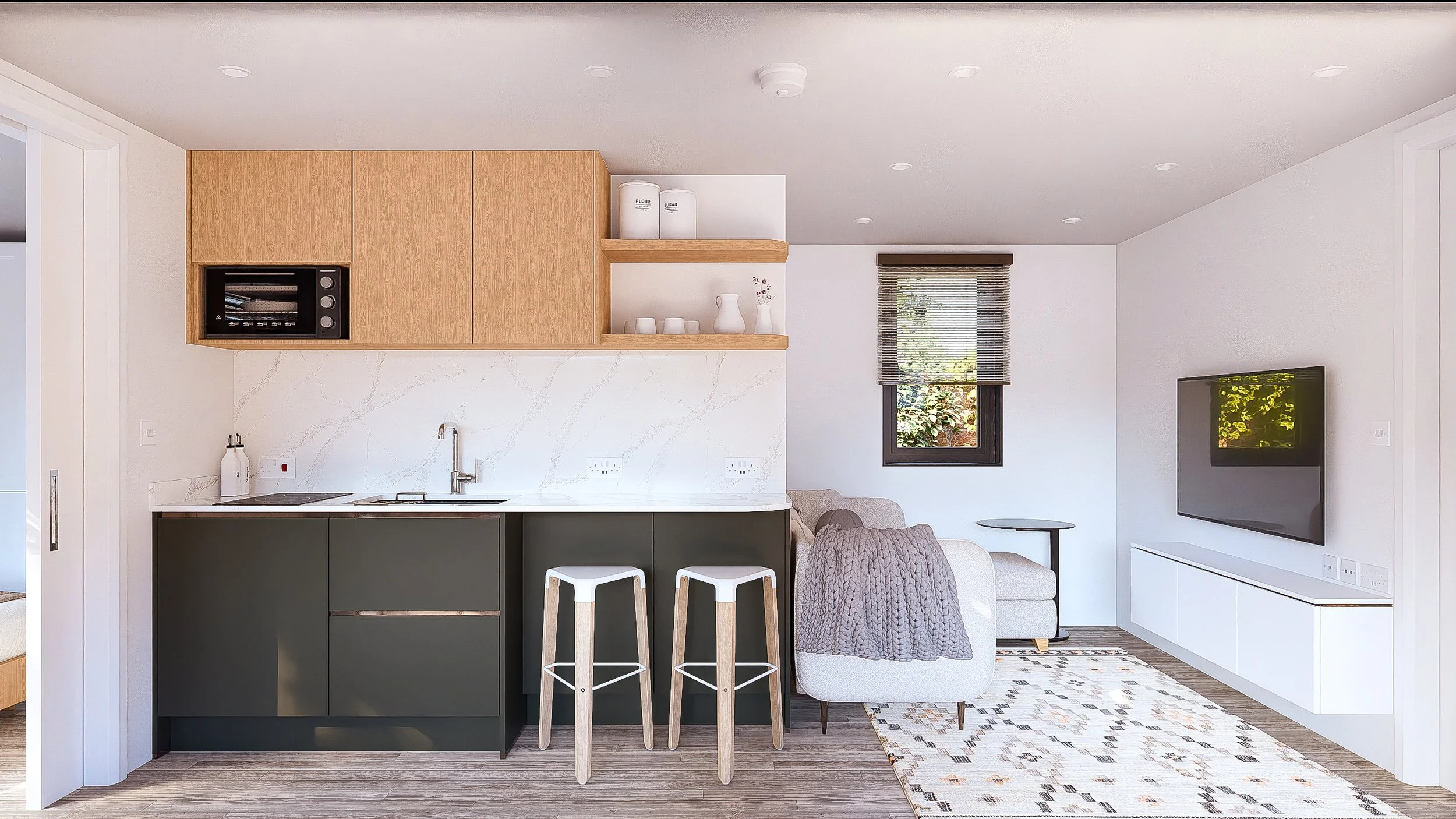 Bauhu hurricane resistant modular hospitality pod Open-plan living area and kitchen with small dining bar, beige sofa with chunky knit blanket, wall-mounted TV, and a window with blinds, modern minimalist style, light wood and black cabinetry.