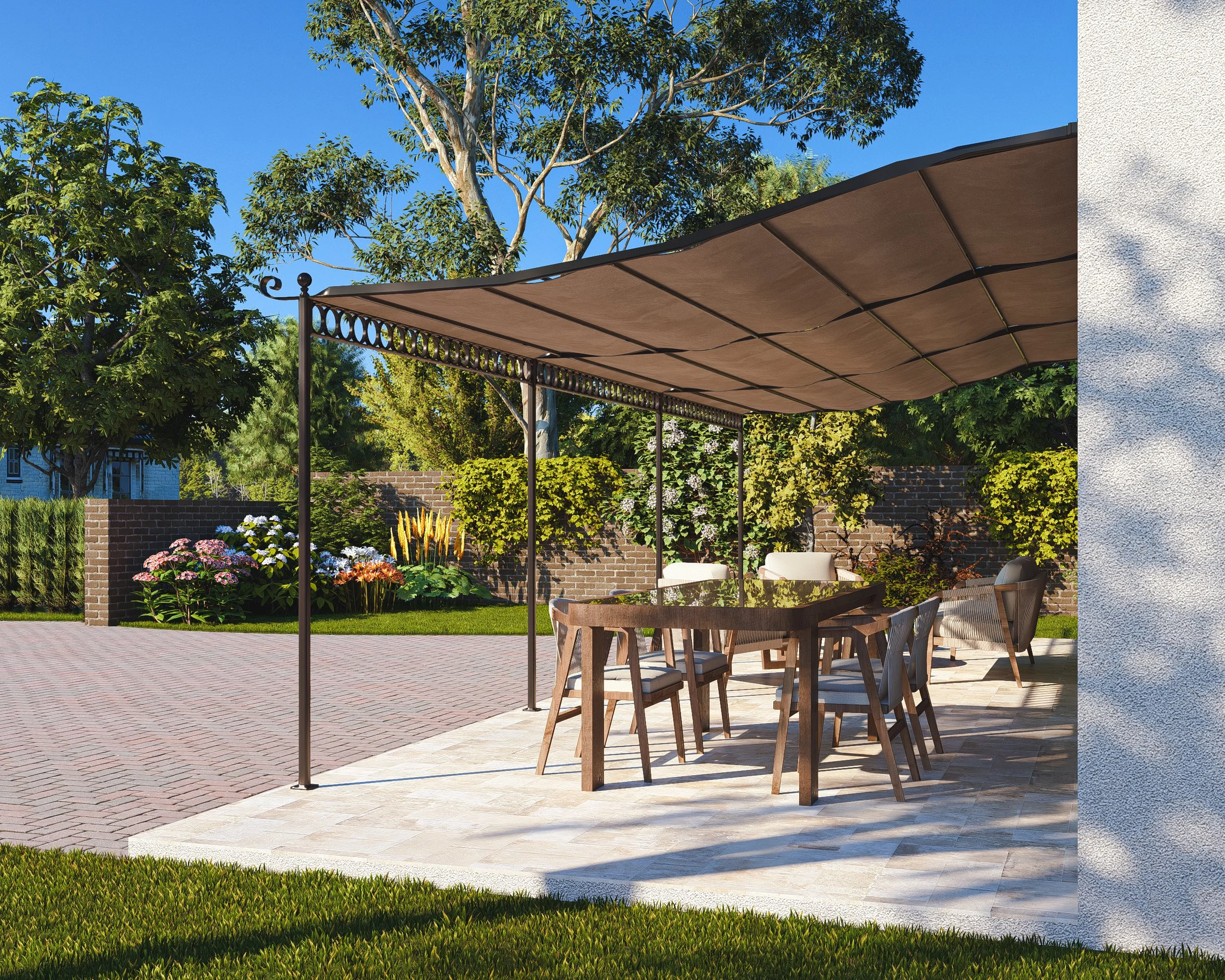 Bauhu hurricane resistant modular hospitality pod Outdoor patio with a wooden dining table and six chairs, shaded by a canopy, surrounded by greenery and colorful flowers, with a brick wall and trees in the background.