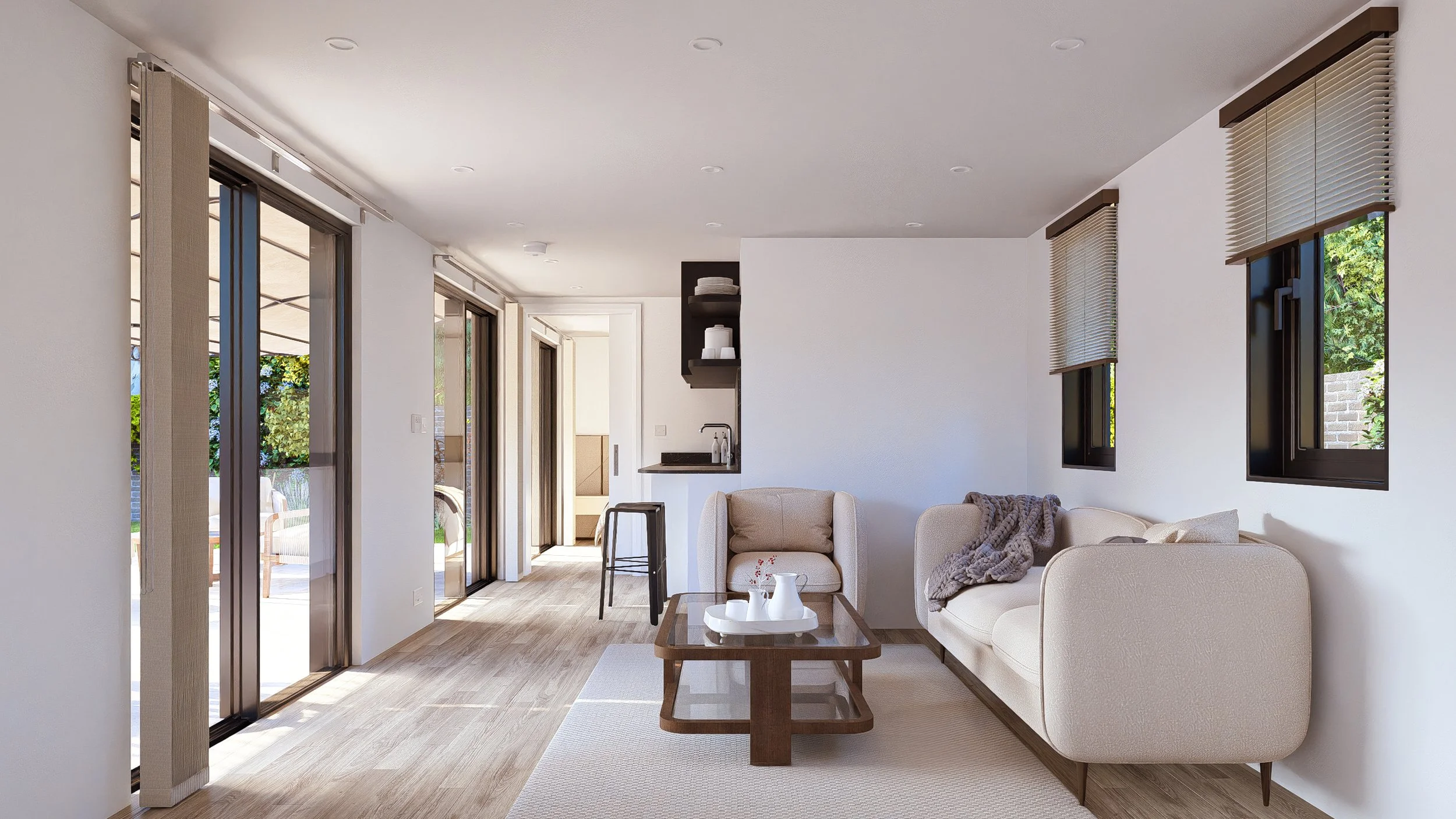 Modern Bauhu hurricane resistant modular hospitality pod  living room with beige sofa, armchair, coffee table, and large sliding glass doors leading outside, with windows and a small kitchenette visible in the background.
