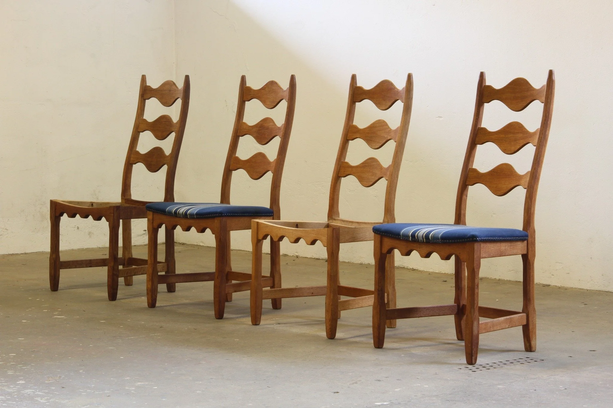 Vintage 1960s Danish Brutalist Oak High Back Chairs, style of Henning Kj&aelig;rnulf 

 SKU: mb00055

Four chairs. Zero compromises. This set of carved oiled oak Razorblade-style ladderback chairs by Edmund J&oslash;rgensen M&oslash;belfabrik is clea
