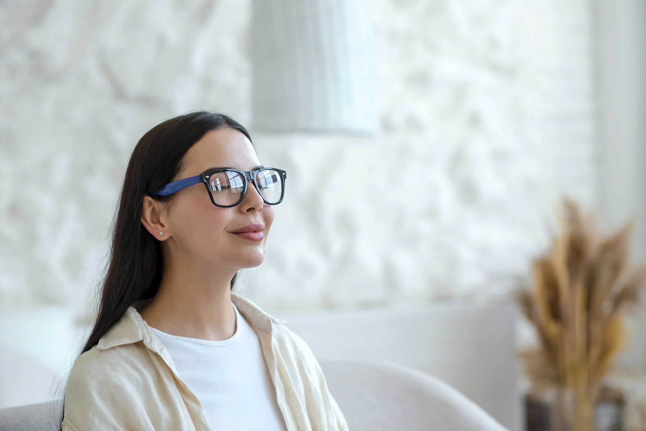 Young woman in glasses relaxes on a couch