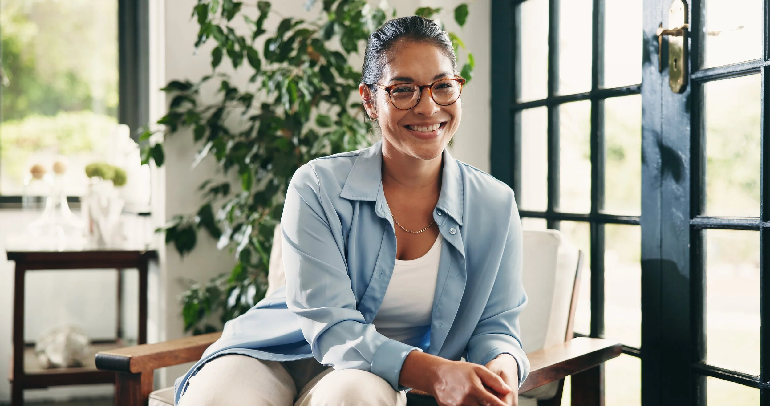Smiling woman in chair with plants in background