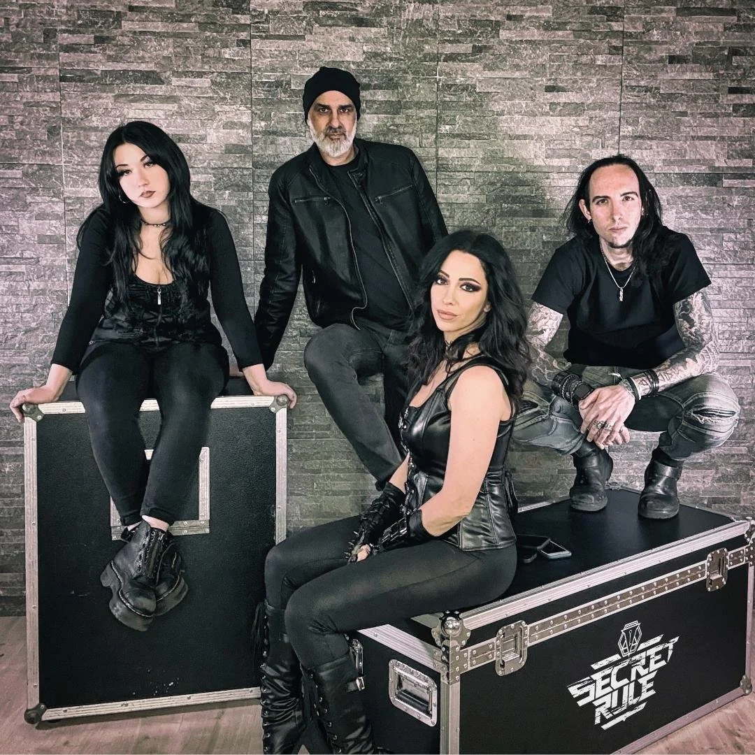 Picture of 4 musicians that make up Secret Rule wearing black.