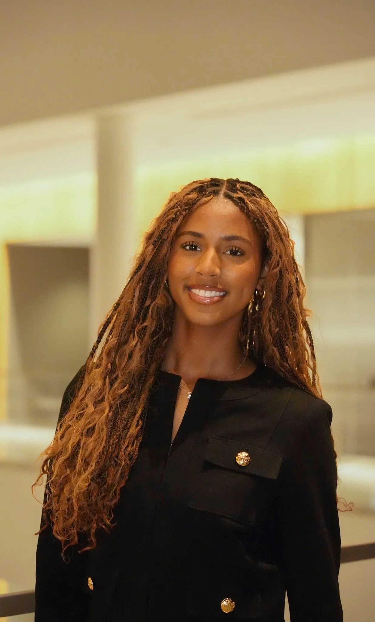 Michigan State University Spartan helmet logo with MSUMA text, in front of a modern building with glass windows and trees.