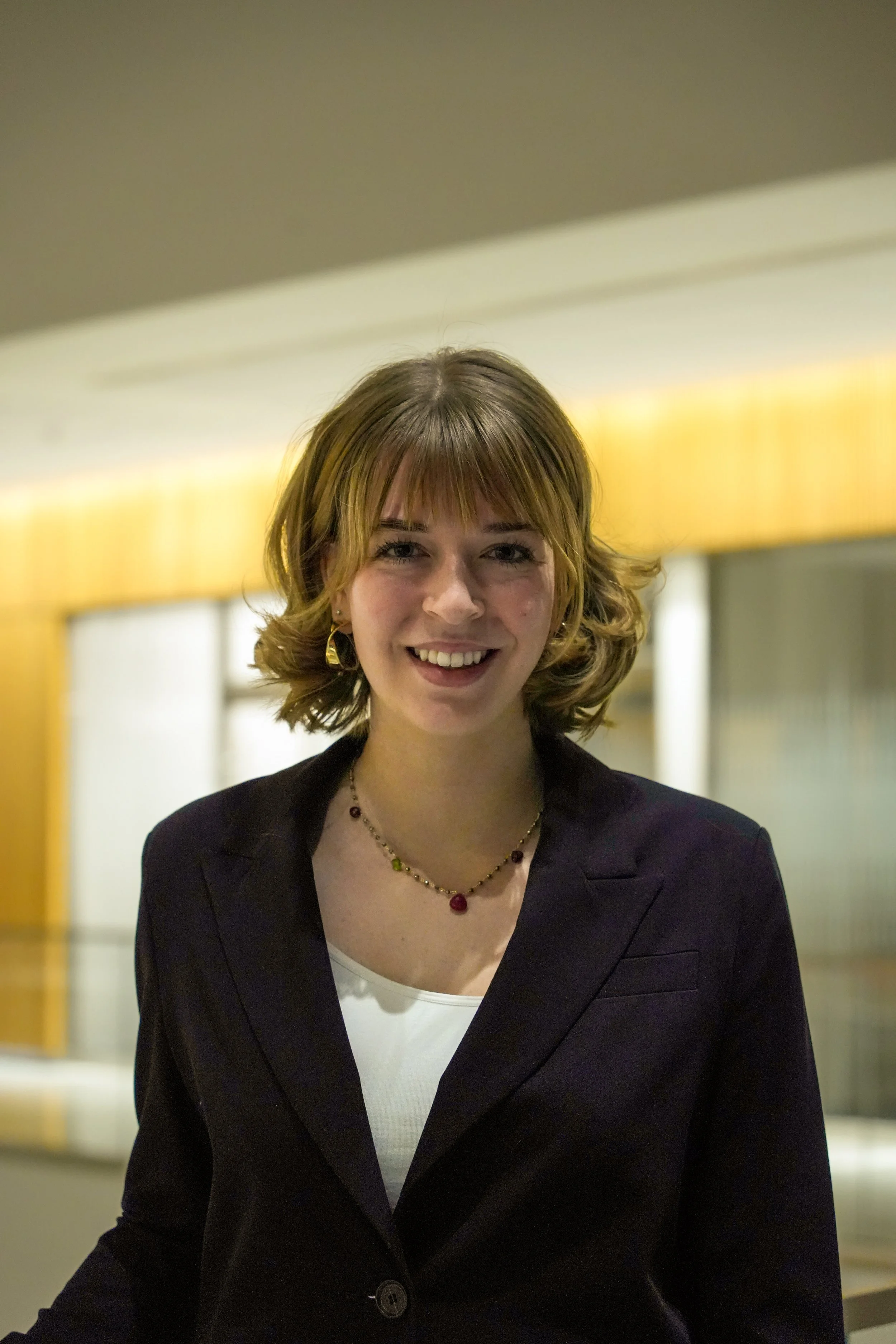 Michigan State University Spartan helmet logo with MSUMA text, in front of a modern building with glass windows and trees.