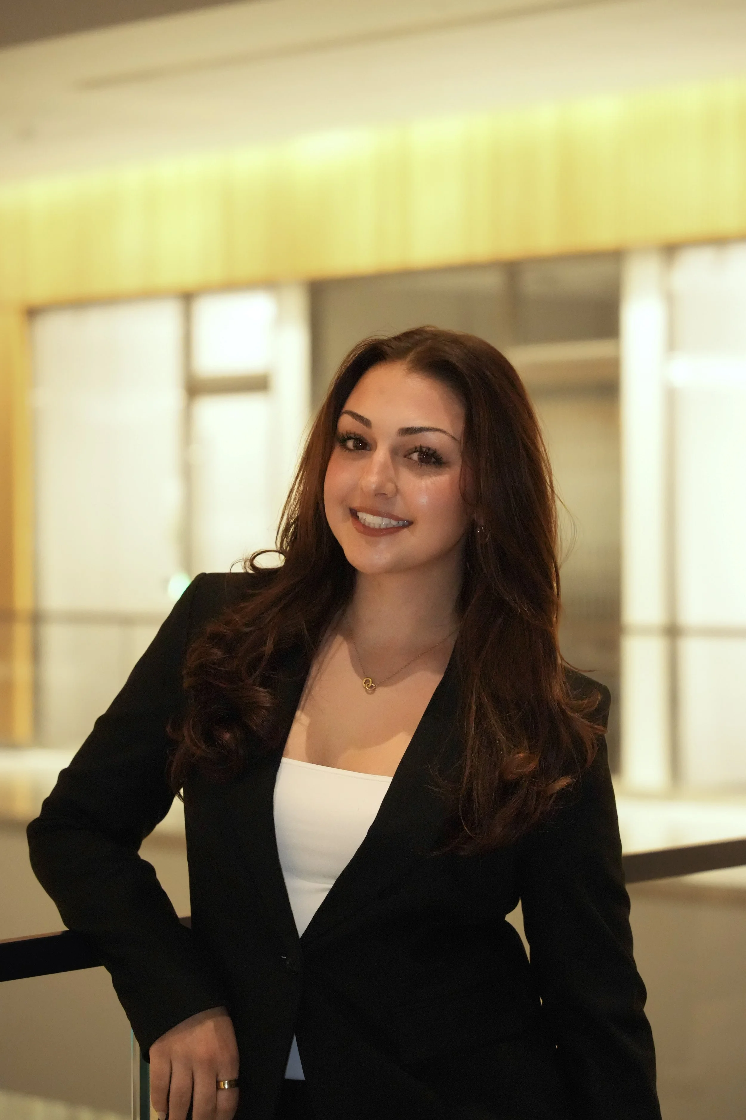 Michigan State University Spartan helmet logo with MSUMA text, in front of a modern building with glass windows and trees.