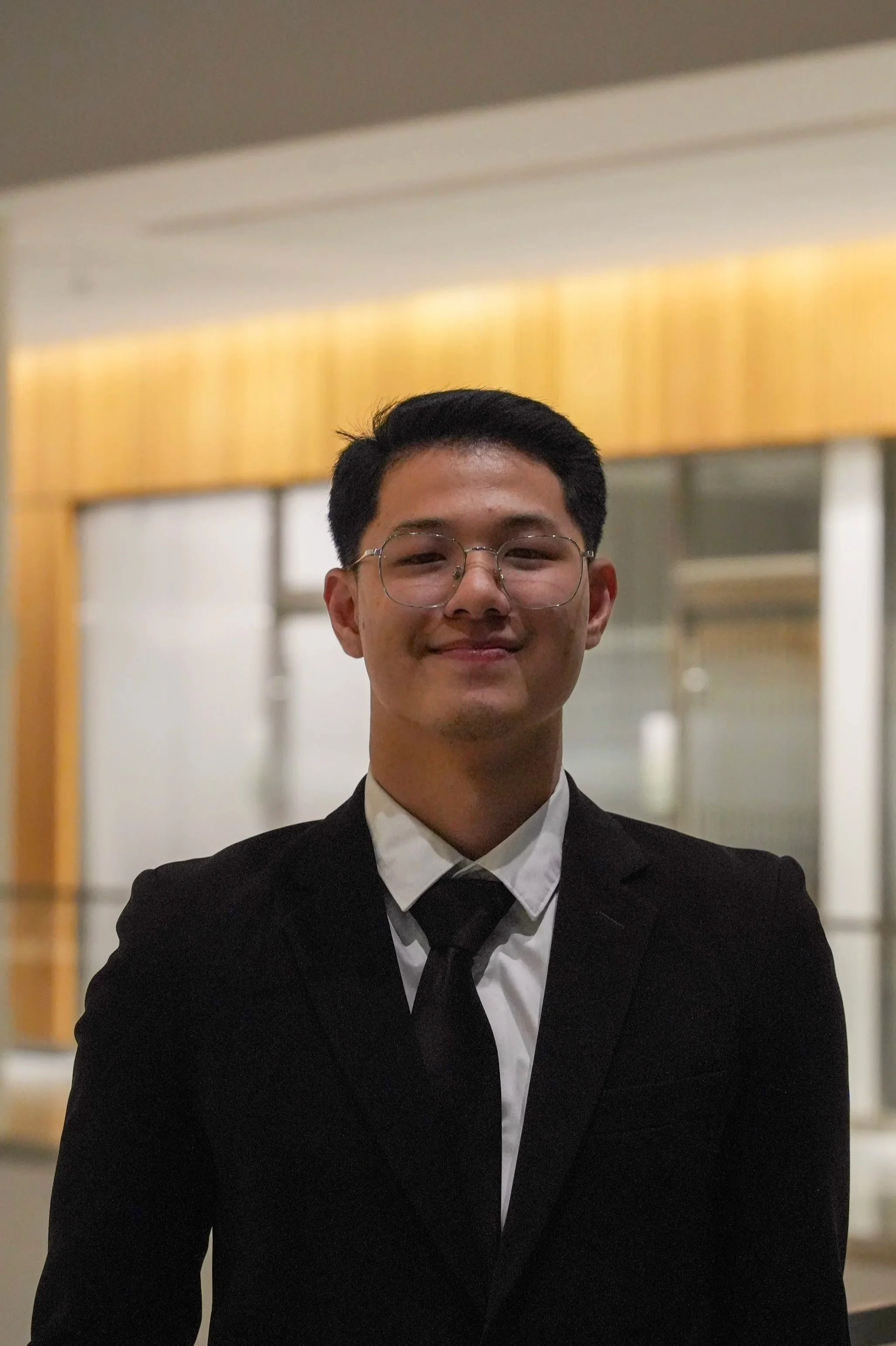 Michigan State University Spartan helmet logo with MSUMA text, in front of a modern building with glass windows and trees.