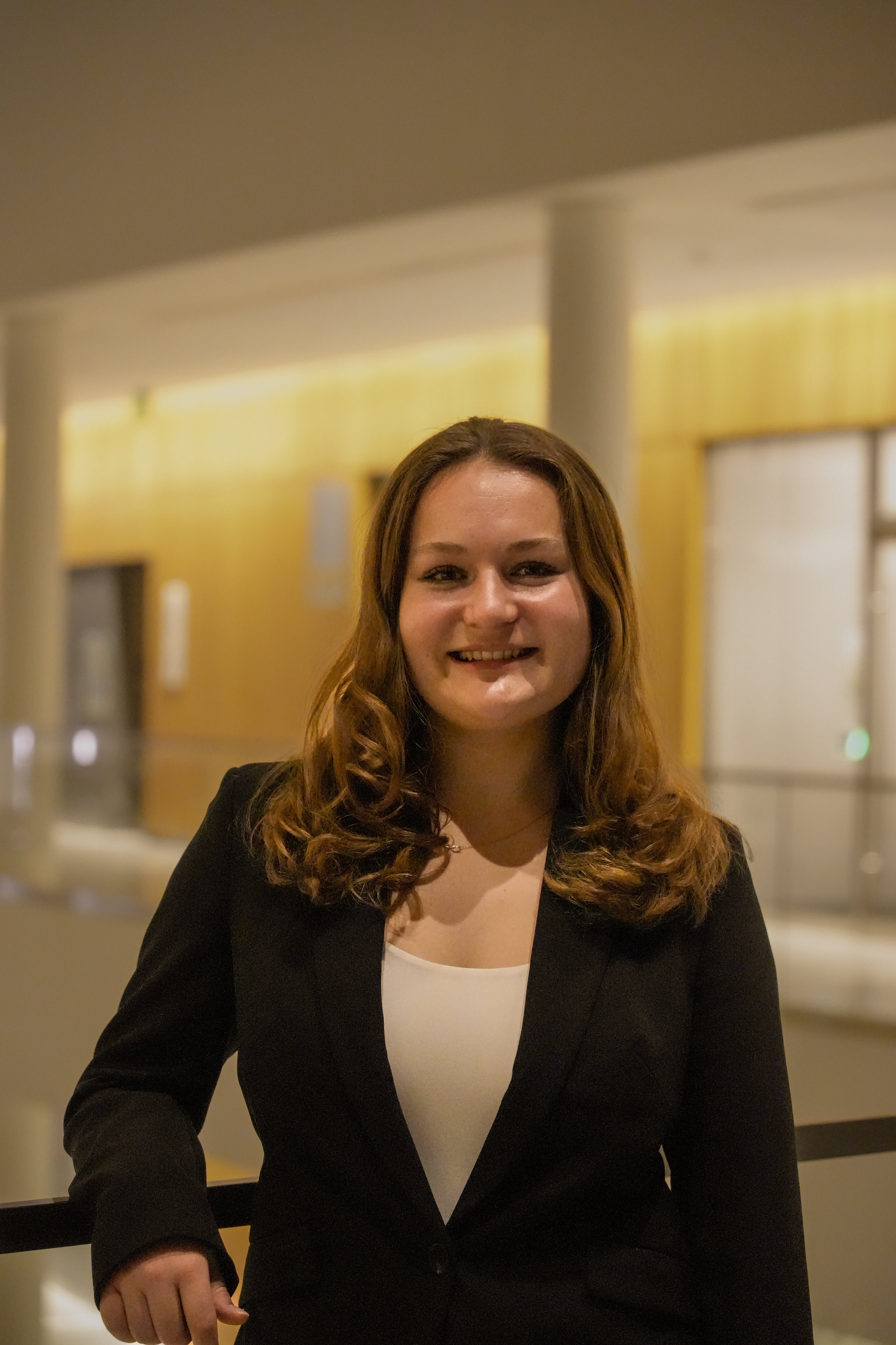 Michigan State University Spartan helmet logo with MSUMA text, in front of a modern building with glass windows and trees.