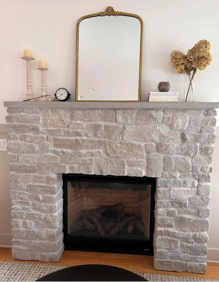 Custom brick fireplace installation by a masonry contractor in Monmouth County NJ featuring a rustic wood mantel and modern gas fireplace.
