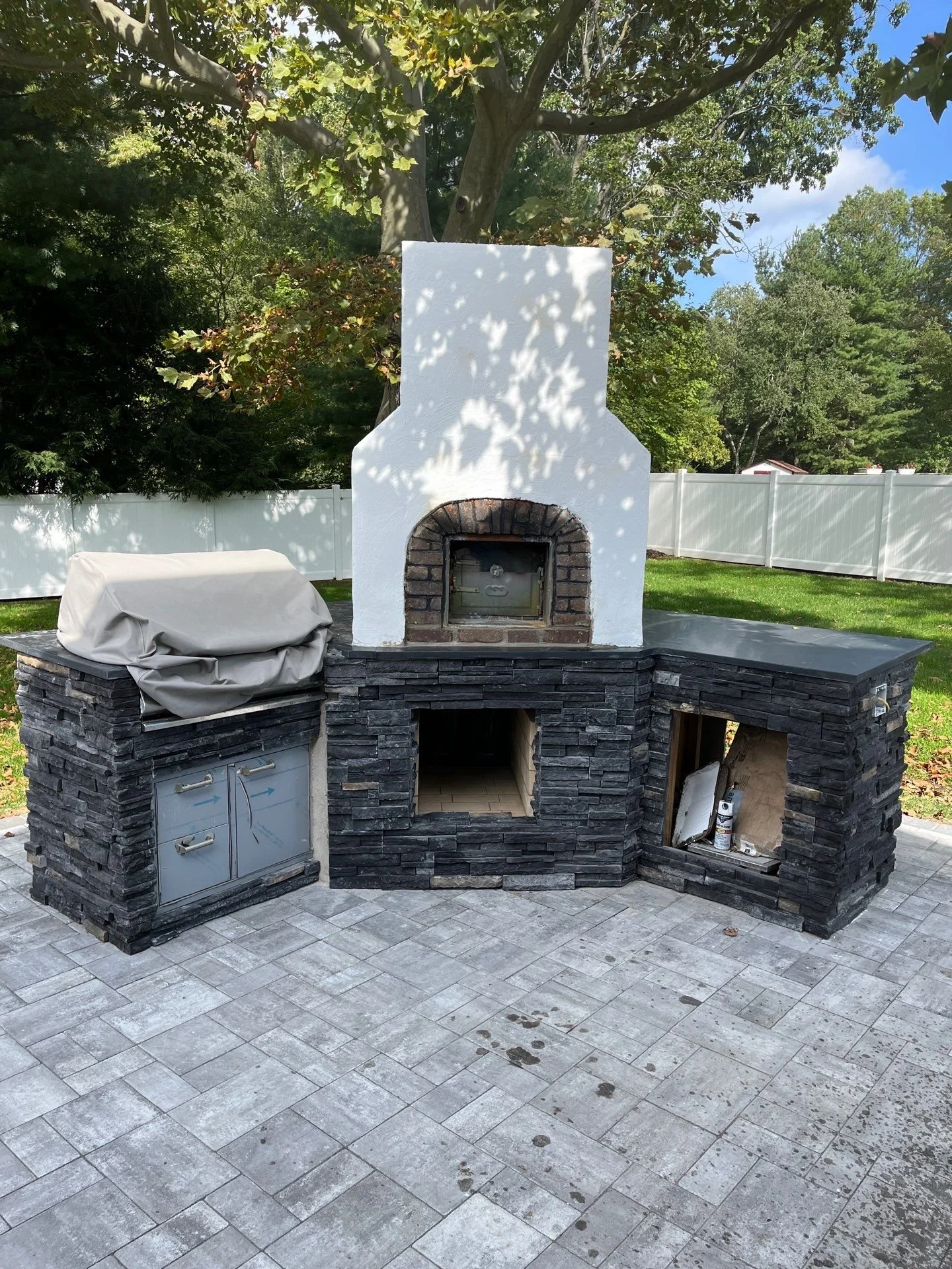 Outdoor stone kitchen and fireplace installation in Monmouth County NJ featuring custom masonry, built-in grill, and durable stone construction.