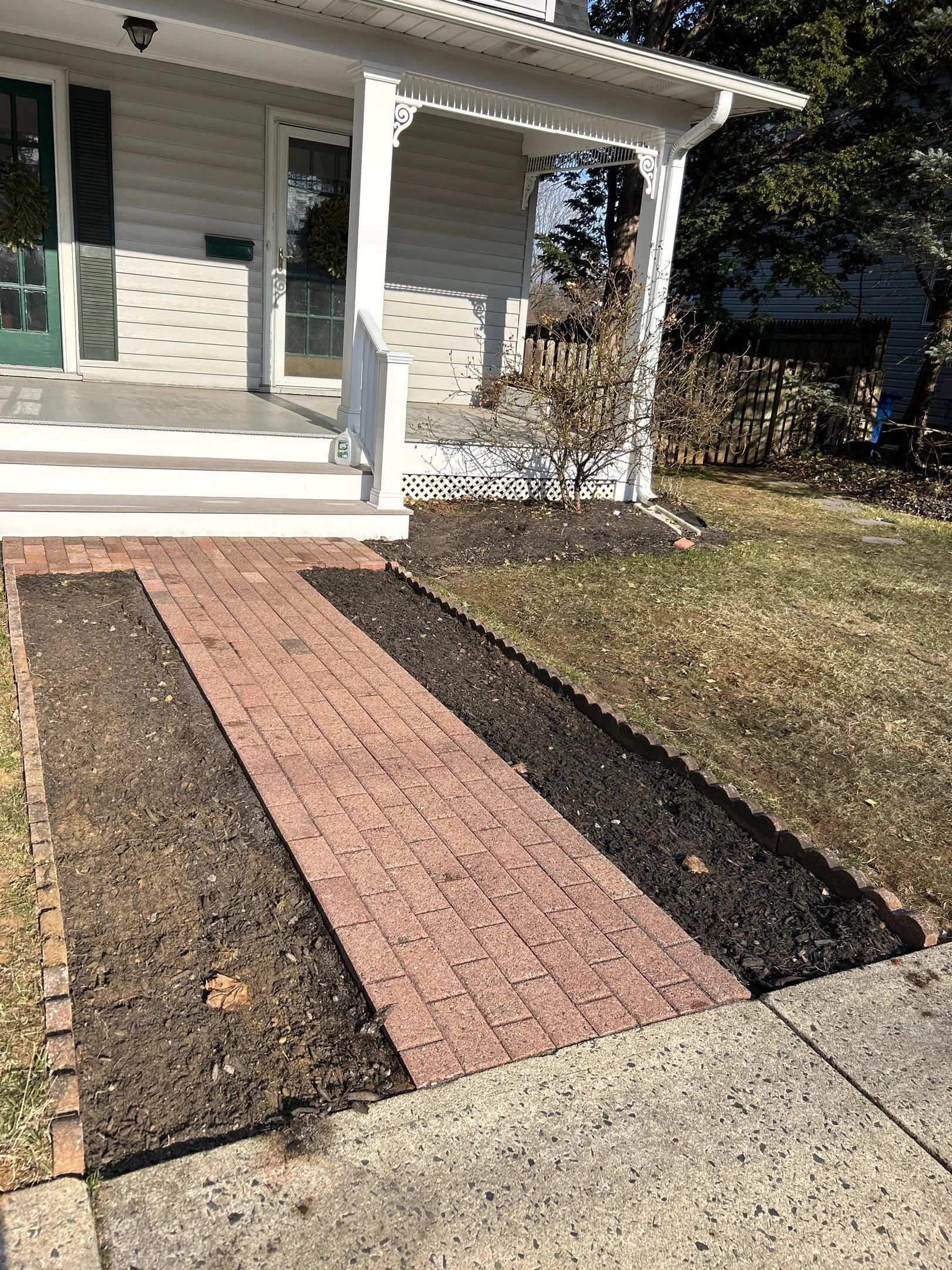 Brick walkway installation in Monmouth County NJ leading to front porch with clean masonry layout and durable outdoor construction.