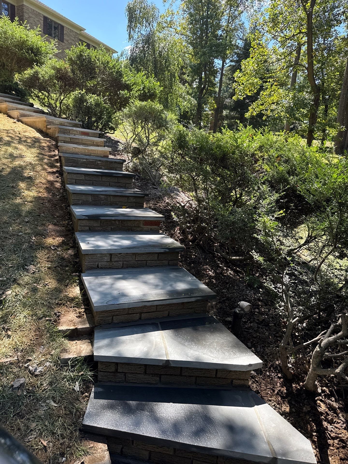 Landscape stone steps installation on sloped yard in Monmouth County NJ featuring natural stone treads and durable outdoor masonry construction.