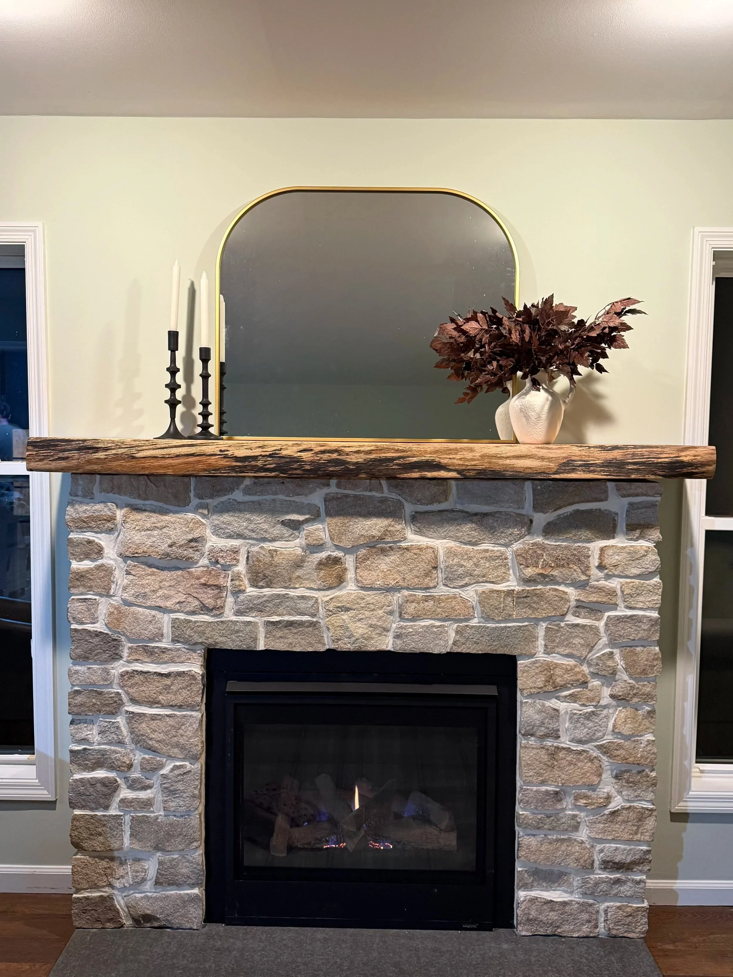 Stone fireplace with wood mantel installation in Monmouth County NJ featuring natural stone masonry and modern fireplace insert.
