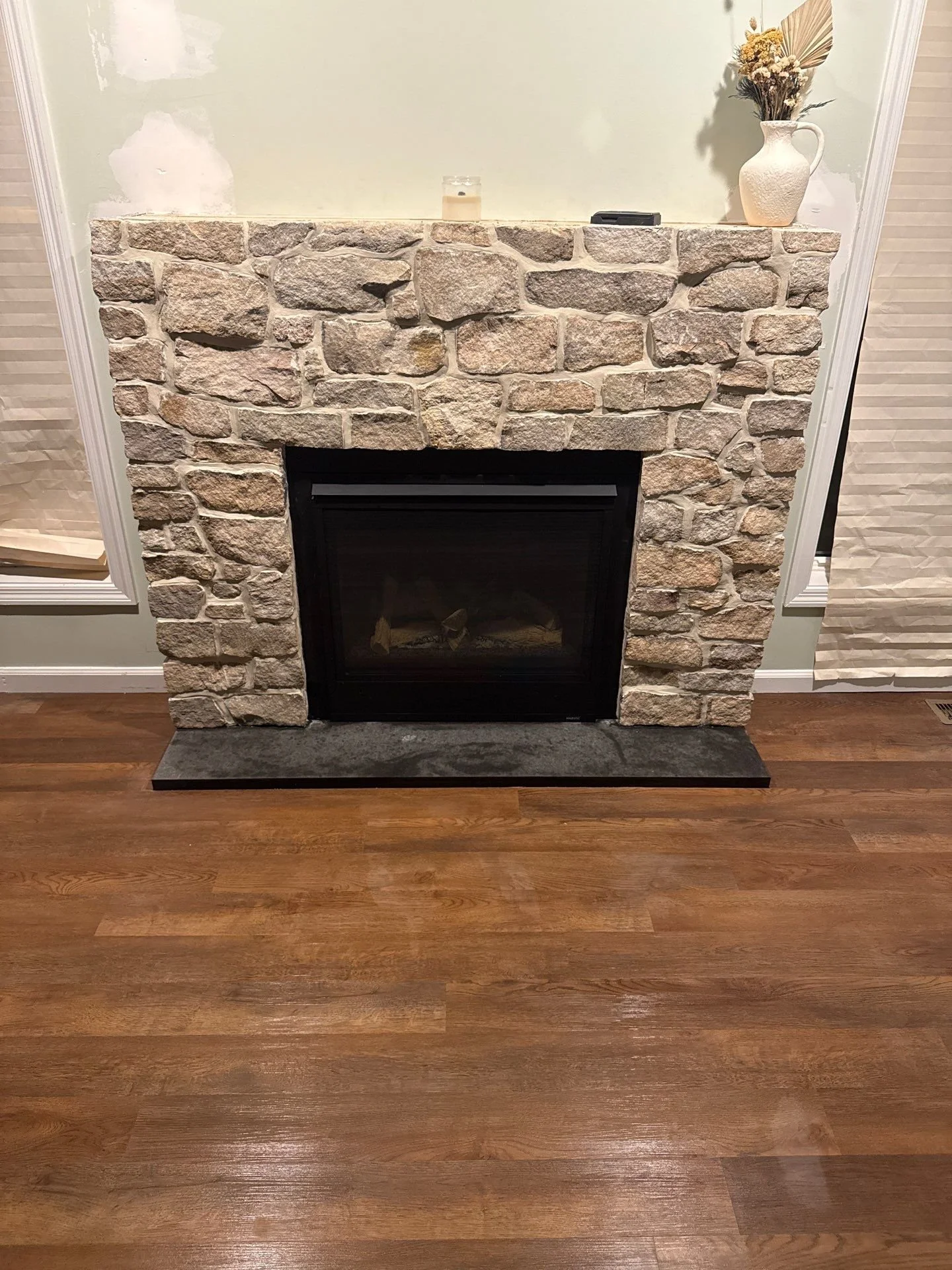 Custom natural stone fireplace installation by a Monmouth County NJ masonry contractor featuring rustic stone surround and modern fireplace insert.