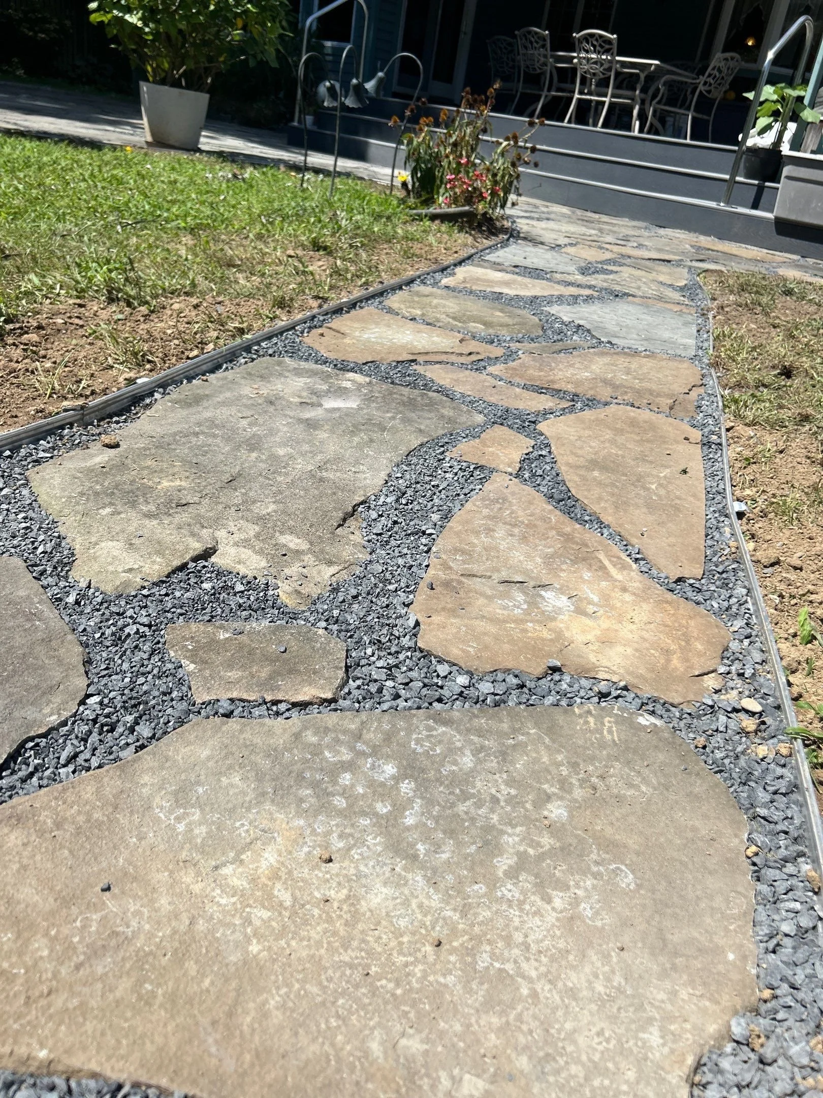 Flagstone walkway installation in Monmouth County NJ featuring natural stone slabs set in gravel for durable and decorative outdoor pathways.