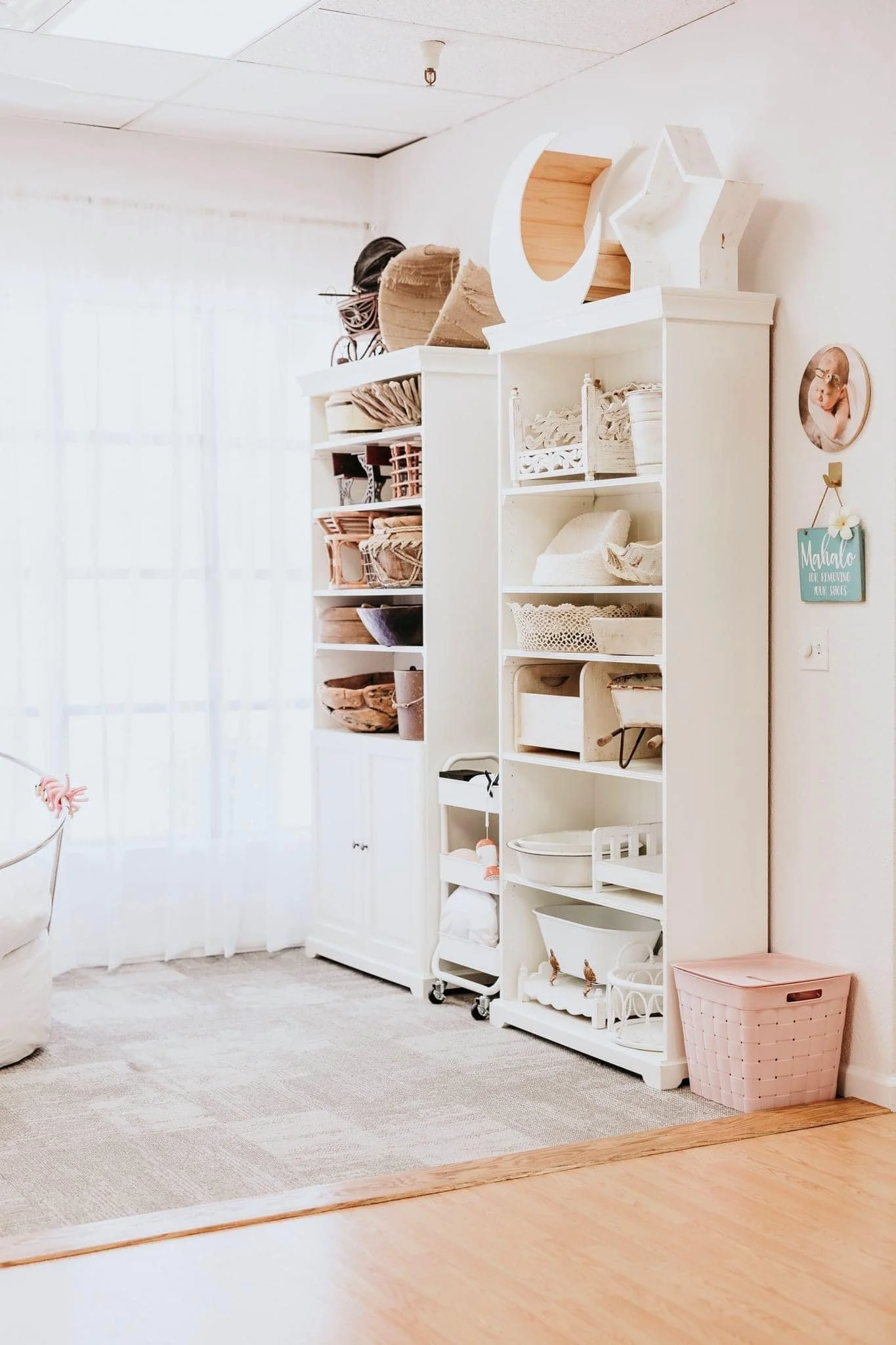 White shelves with various baby photography props.