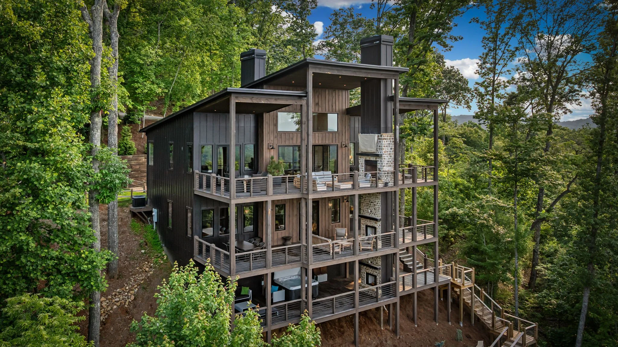 Experience mountain luxury at this striking retreat featuring multi-level decks, outdoor lounge areas, panoramic mountain views, floor-to-ceiling windows, & stunning modern design—perfect for relaxing, entertaining, and more.