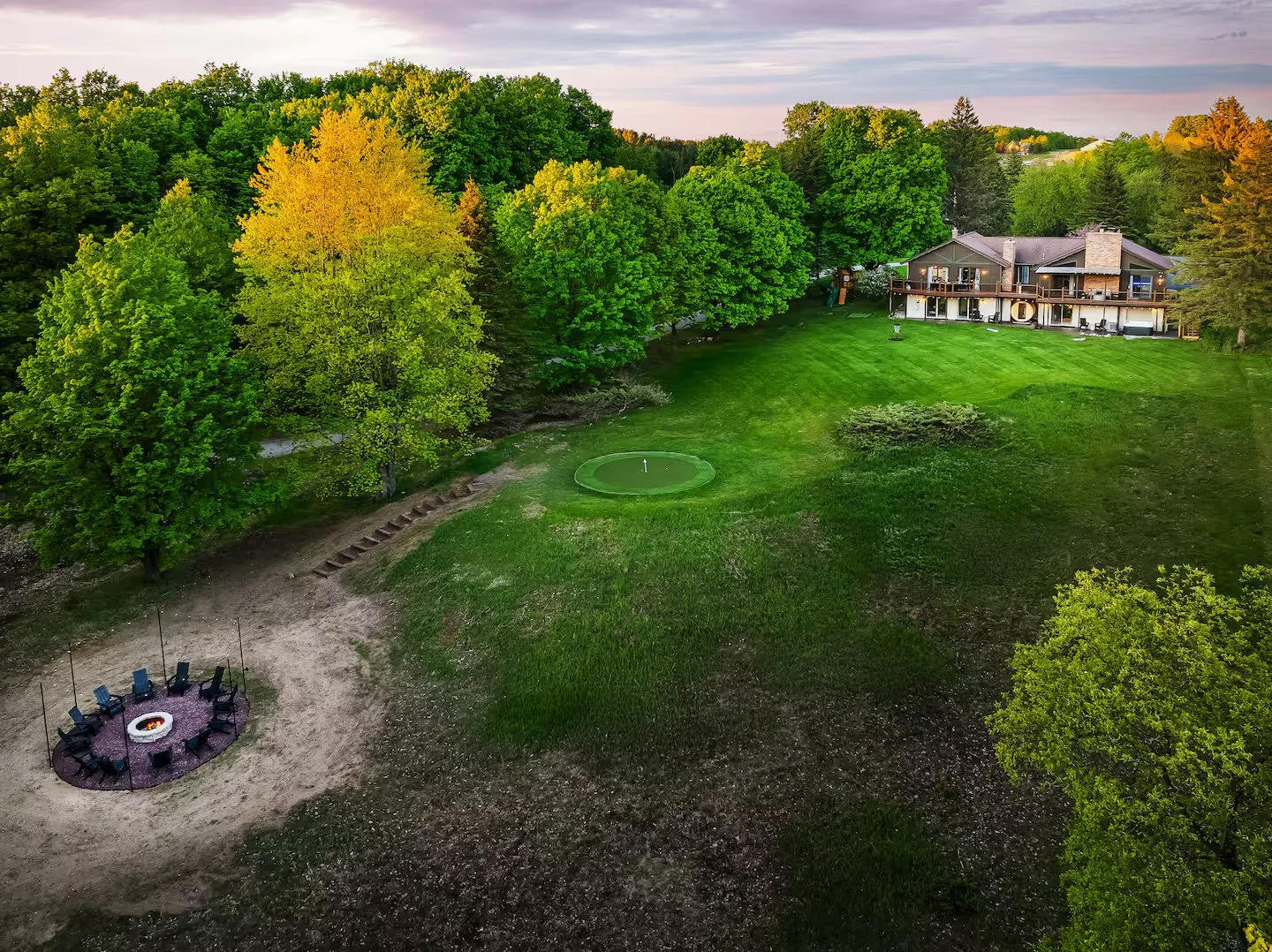 Enjoy space & seclusion w/ over 2 acres at the home. The putting green & private golf hole gives you room to work on your game! The firepit down below is tucked away in nature, the perfect place for late night drinks + s’more’s with family +friends!
