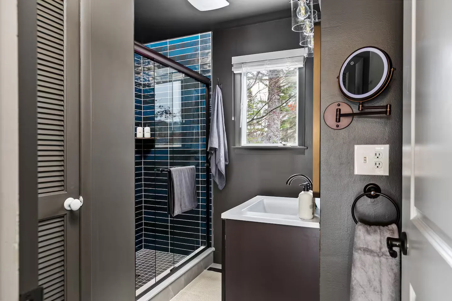 The upstairs recently renovated shared bath was completely redone from the ground up. With sleek blue tile, a glass shower door, and a convenient linen closet, it is located next to the main-level bedroom combining modern style & practical design.
