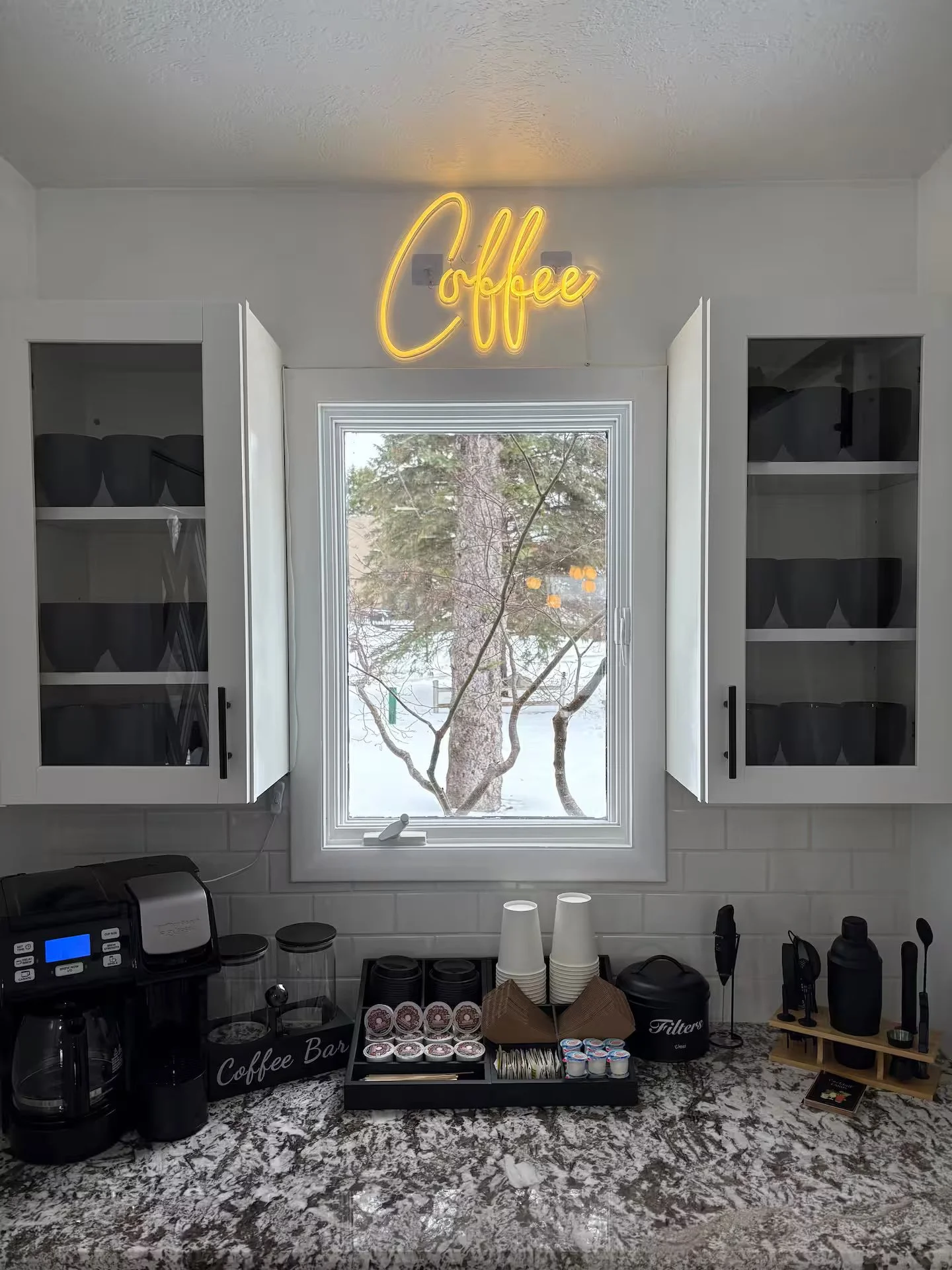 The coffee bar is fully equipped w/ a regular drip coffee maker and Keurig single-serve machine. It includes creamer, sugar, to-go cups, sleeves, stir sticks, mugs, & ground coffee, ensuring everything you need for a perfect cup is readily available.