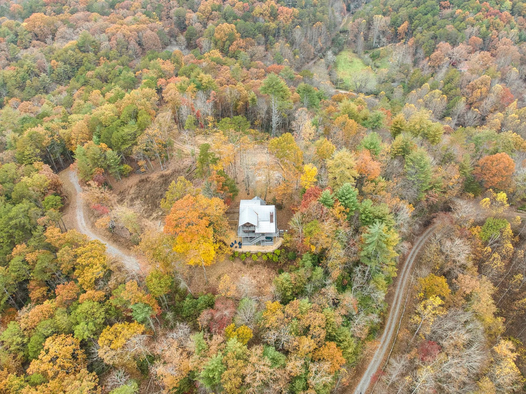 Check out this bird’s-eye view of the private outdoor oasis featuring a fire-pit, jacuzzi, playground, and a fully fenced-in yard with a wraparound porch - perfect for family-friendly and pet-friendly fun in a secluded North Georgia mountain setting.