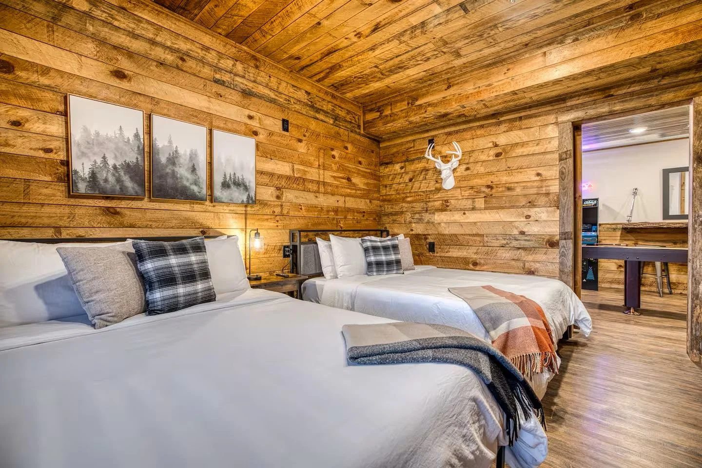 Bedroom 3 (Downstairs) features two queen beds - perfect for teens, extra sleeping space, or young families traveling together. Located just off the game room, it includes a smart TV with streaming and cable plus a pack-and-play for added convenience
