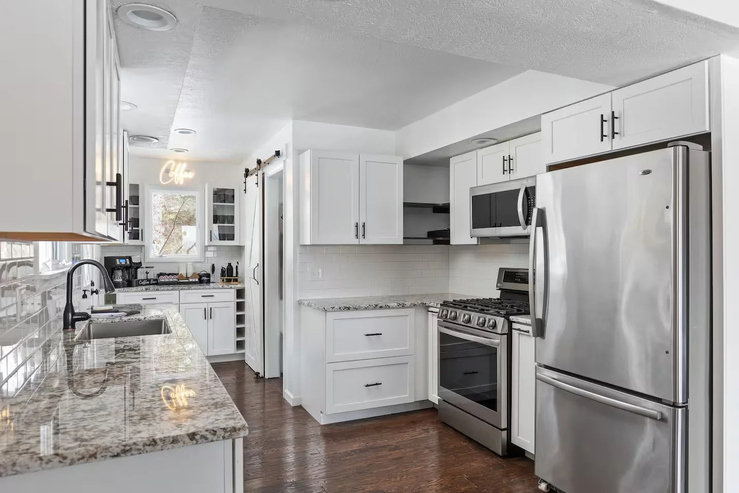 The grand dining room has vaulted ceilings and 2 separate dining tables, comfortably seating 16. Filled with natural light from numerous windows, the space is bright and airy. Direct patio access enhances the flow, perfect for indoor-outdoor living.
