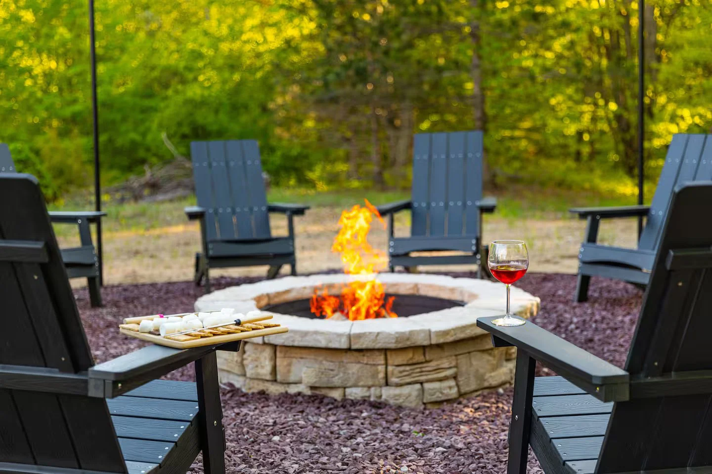 Relax and enjoy a large cozy outdoor firepit surrounded by Adirondack chairs, glowing stonework, and crackling flames with string lights overhead. Open up a bottle of wine, roast some marshmallows, and make some s’mores in the evening under the stars