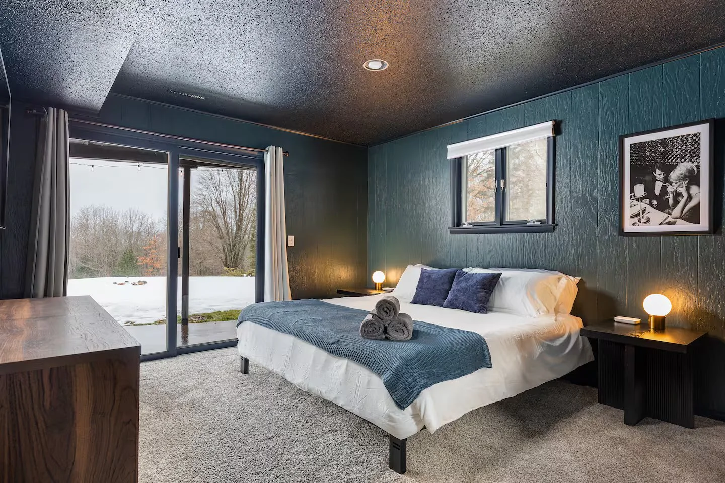 “Bedroom 3” is a downstairs corner unit with 2 windows offering plenty of natural light. This king-size suite features modern, sleek décor & design, direct patio access, closet storage, a smart TV, and high-quality linens for added comfort and style.