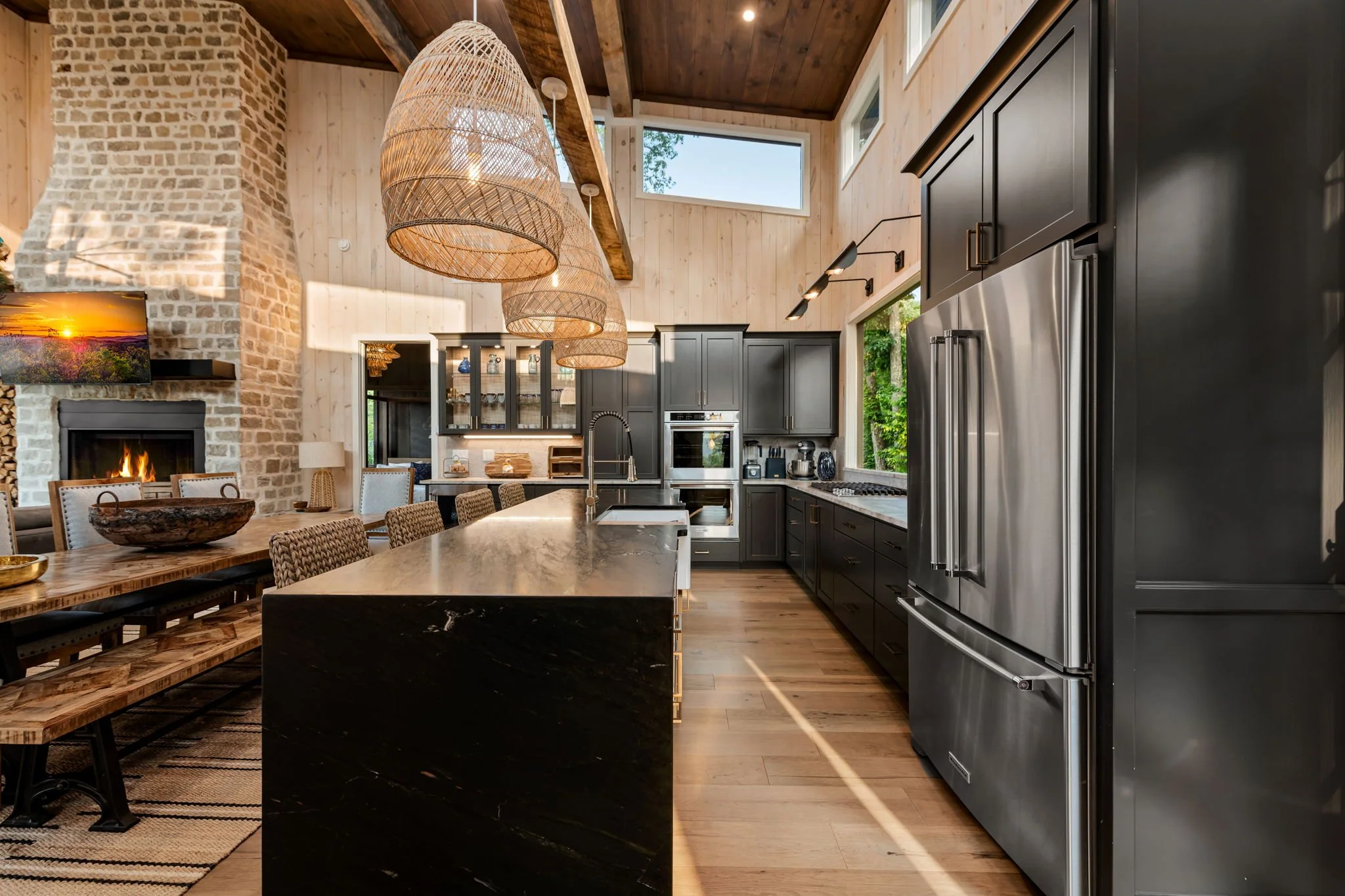 Cook & gather in this luxury chef’s kitchen featuring a large island with seating, stainless steel appliances, double ovens, French-door refrigerator, custom cabinetry, pendant lighting, and open-concept dining—perfect for entertaining in style.