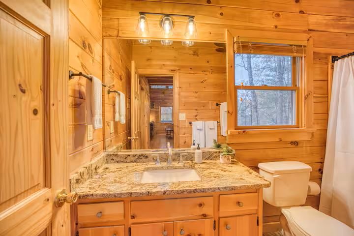 The Main-Level Bathroom sits directly next to the Main-Level King Bedroom and features a lightly refreshed look with new fixtures, a shower/tub combo, essential toiletries, and a hair dryer - providing a clean, convenient space for everyday comfort.