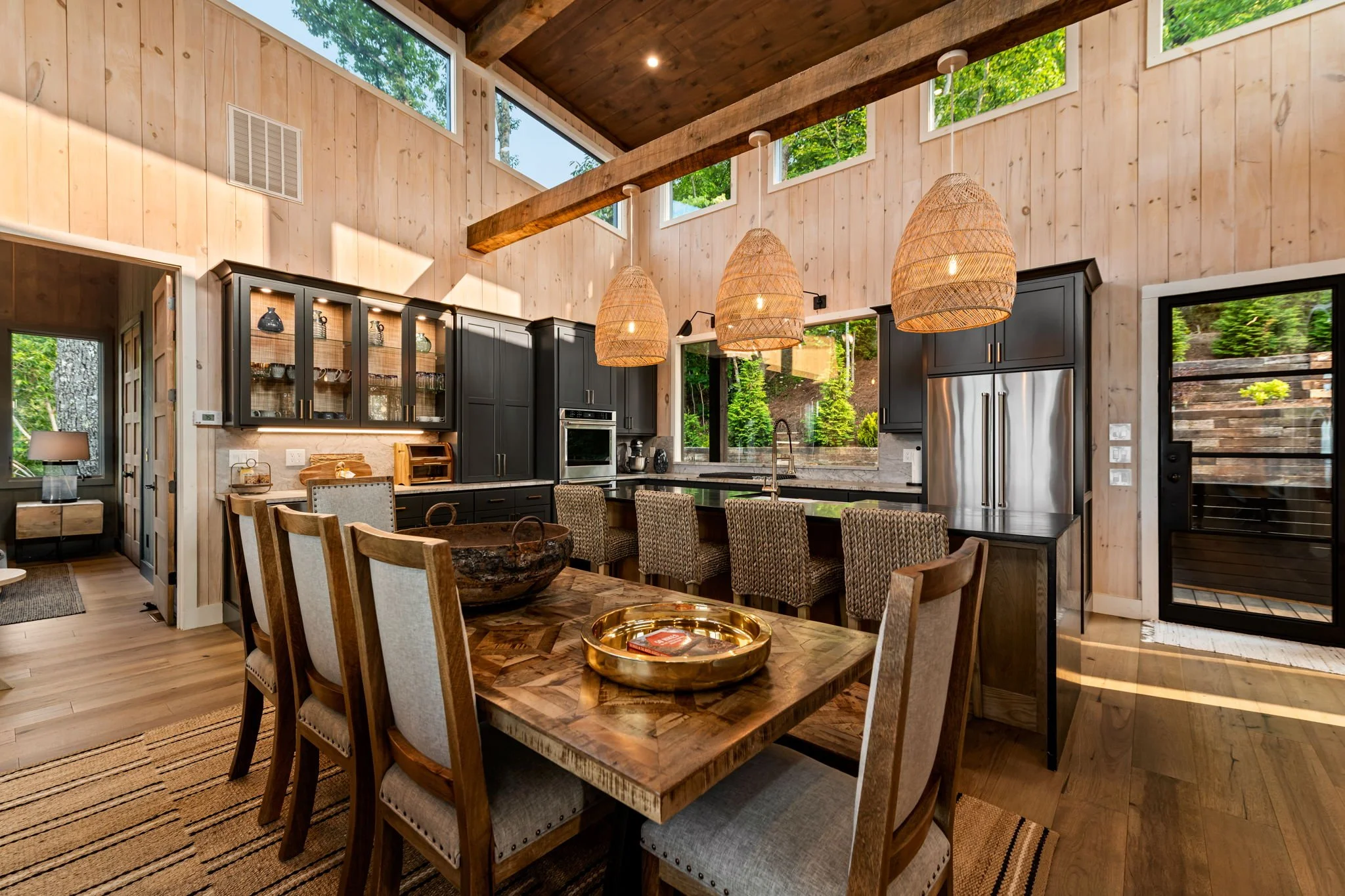 Dine & entertain in this stunning open-concept space featuring a chef’s kitchen with large island seating, stainless steel appliances, custom cabinetry, designer pendant lighting, and a spacious dining table—perfect for gathering in style.