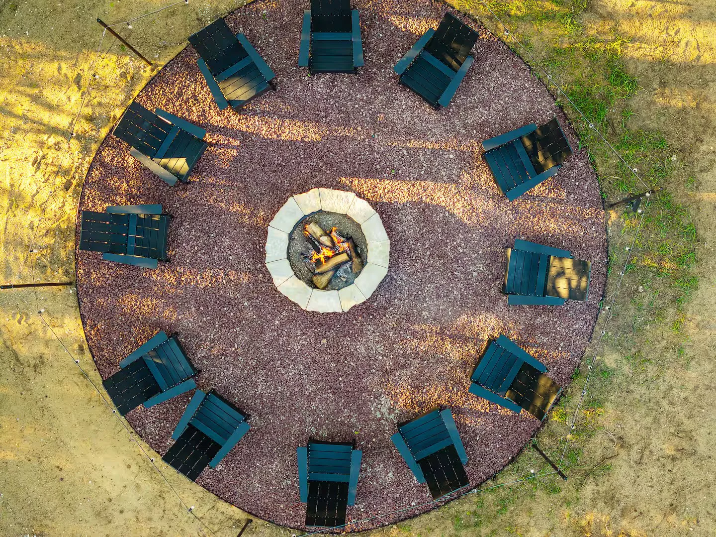 Relax and enjoy a large cozy outdoor firepit surrounded by Adirondack chairs, glowing stonework, and crackling flames with string lights overhead. Open up a bottle of wine, roast some marshmallows, and make some s’mores in the evening under the stars