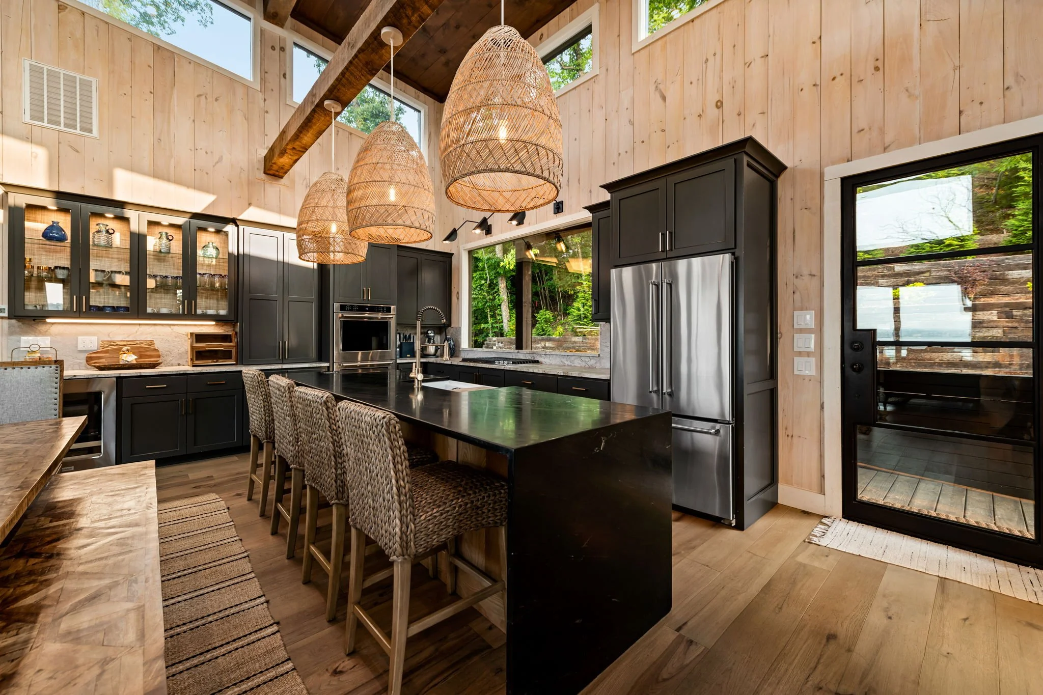 Gather in the chef’s kitchen w/ an oversized island, bar seating, designer pendant lighting, stainless steel appliances, double ovens, & custom cabinetry. Soaring ceilings & an open layout create an elegant space for cooking, dining, & entertaining.