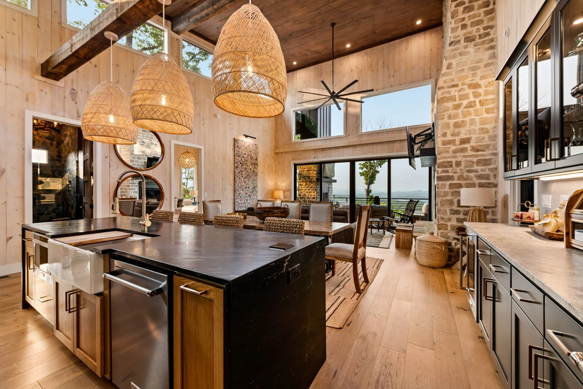 Entertain in the chef’s kitchen featuring a spacious island, bar seating, designer pendant lighting, premium appliances, beverage fridge, and sleek cabinetry. The open layout flows into dining and living spaces with soaring ceilings & mountain views.