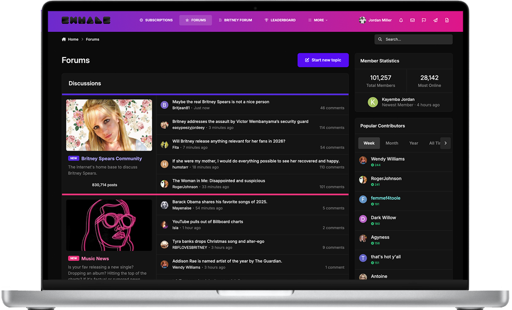 Laptop screen displaying a dark themed online forum dedicated to Britney Spears, with discussion topics and user comments. The header has purple and pink design elements, including navigation links, search bar, and user profile.