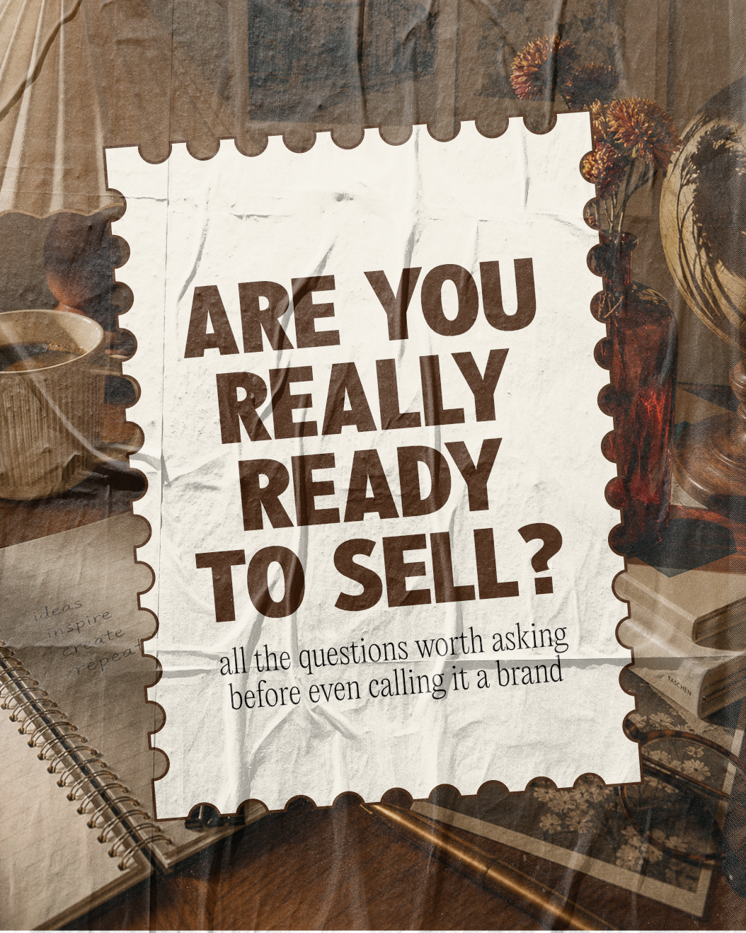 A crumpled paper with the bold text "Are you really ready to sell?" and smaller text "all the questions worth asking before even calling it a brand". Surrounding objects include a notebook, a pen, a coffee mug, a flower vase with dried flowers, and decorative items on a wooden surface.