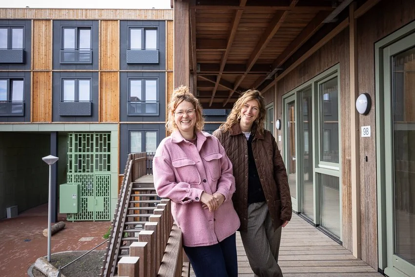 twee vrouwen van Kollectief Thuis staan bij een gebouw
