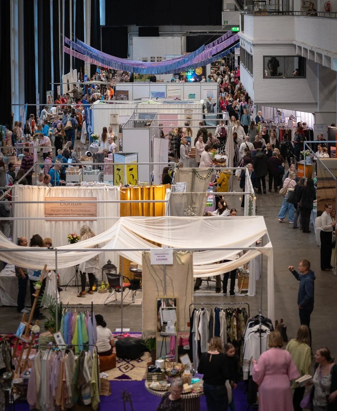 Merikaapelihallin market-alue täynnä kävijöitä ja näytteilleasettajien kojuja Joogafestivaaleilla