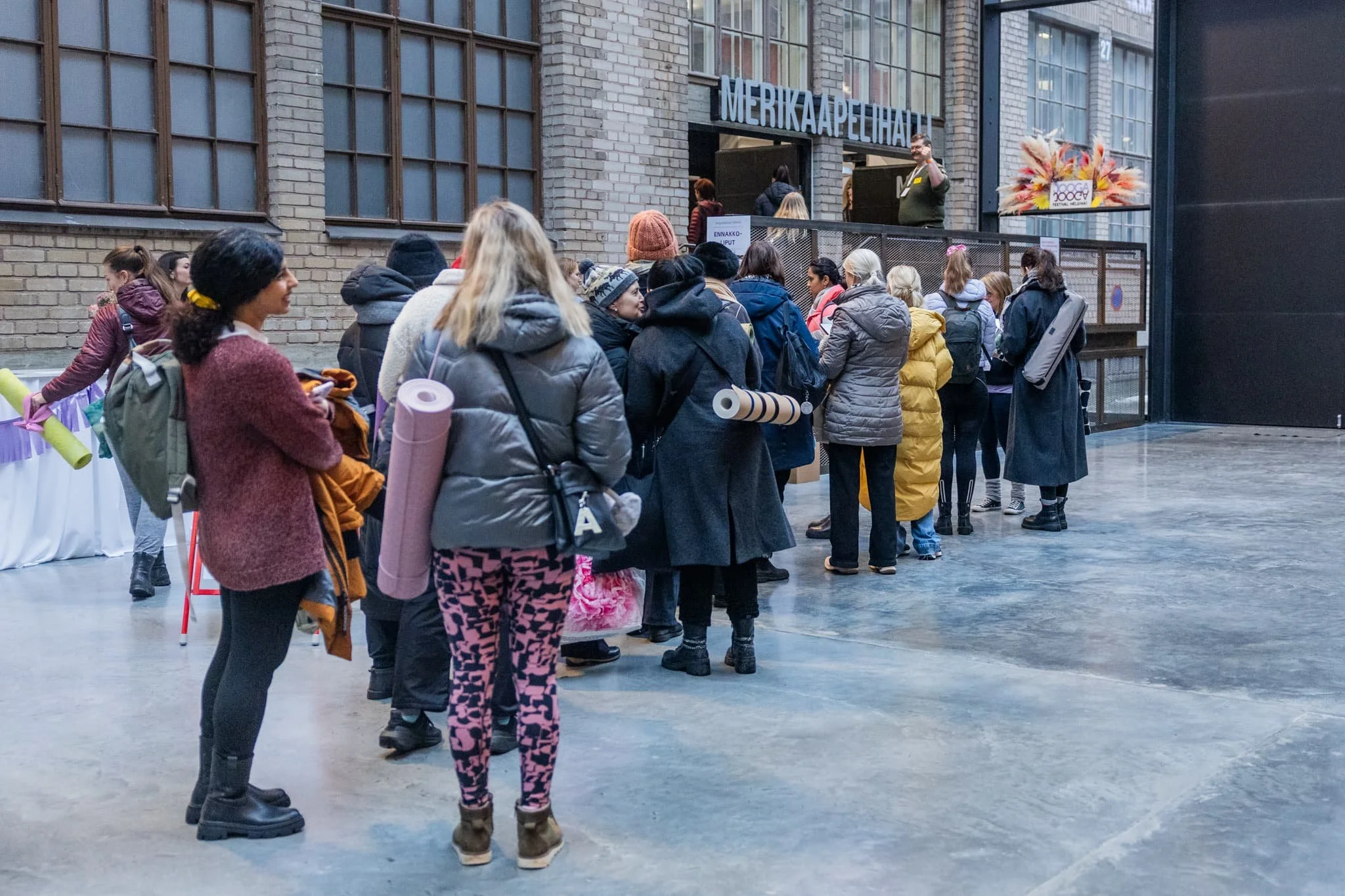Kävijöitä joogamatot mukanaan Kaapelitehtaan Lasipihalla