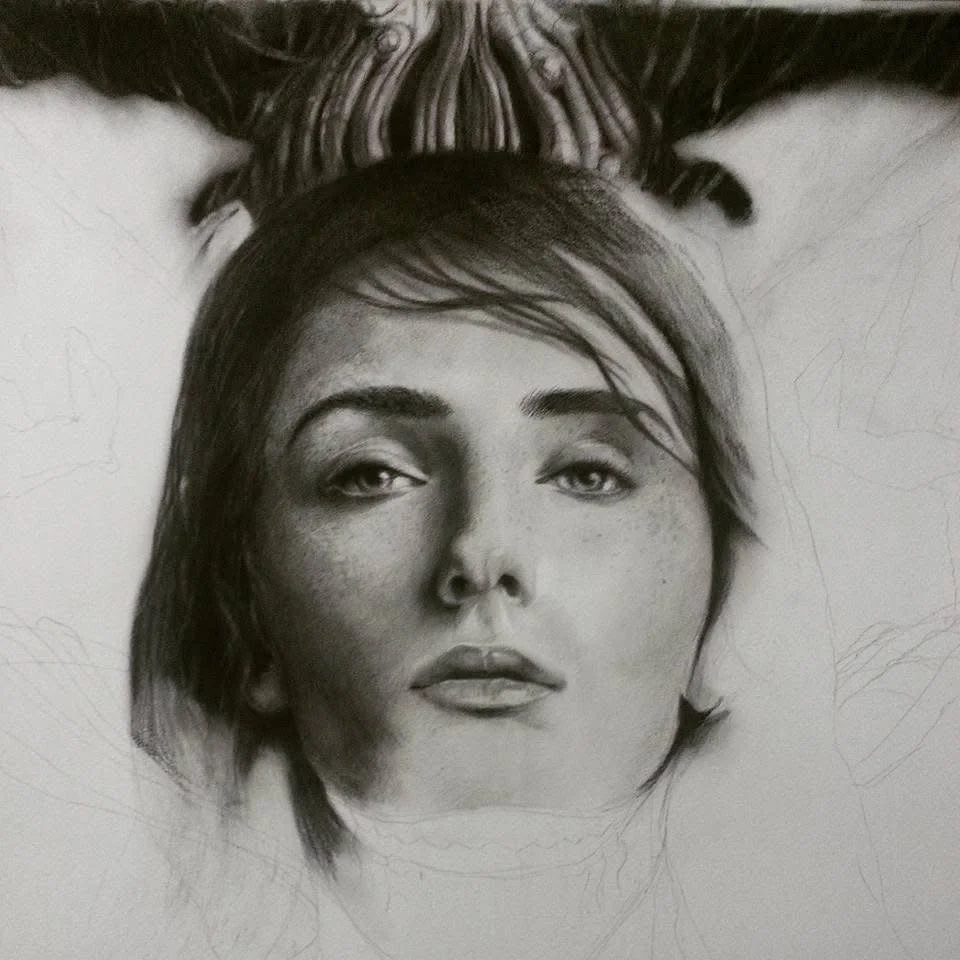 Charcoal portrait of a freckled woman, work in progress