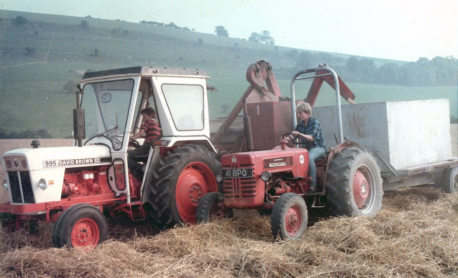 Two people on tractors, one David Brown 995 and one Massey Ferguson, in a field.
