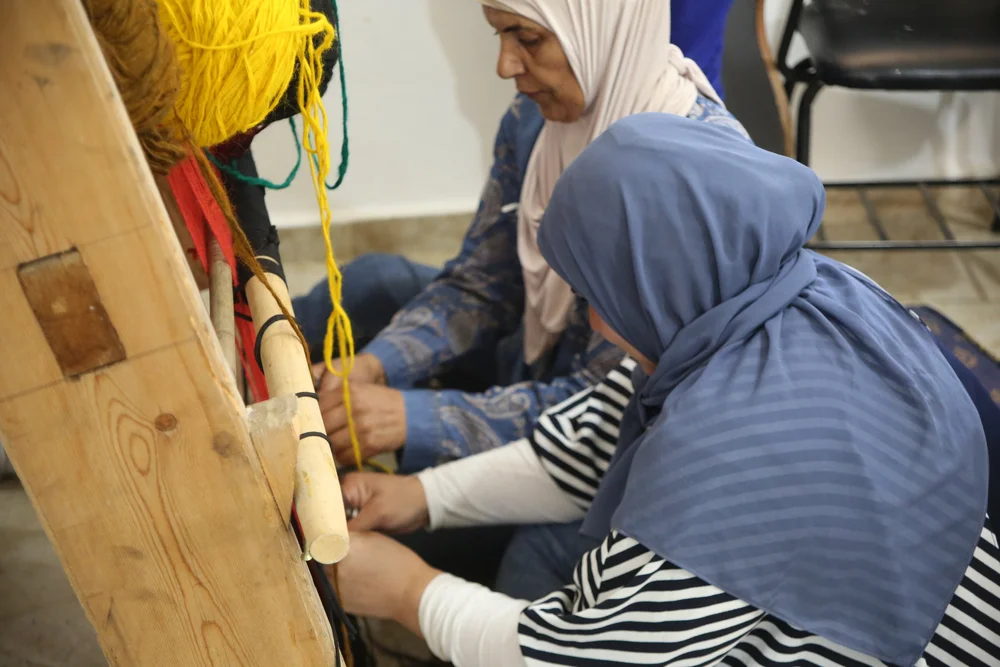 Women participating in a Peace of Art weaving activity